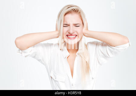 Young businesswoman couvrant ses oreilles et crier avec les yeux fermé sur fond blanc Banque D'Images