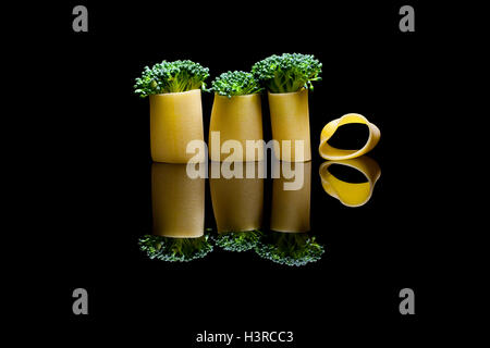 Un groupe de trois pâtes brocoli intégré dans une réflexion sur les manicotti noir backround Banque D'Images