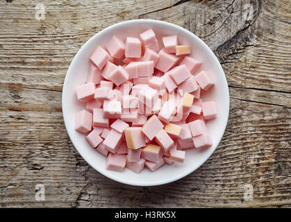 Bol blanc saucisse de jambon haché sur table en bois, vue du dessus Banque D'Images