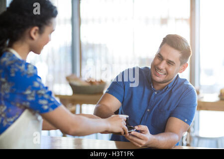 Serveuse de servir une tasse de café au client Banque D'Images