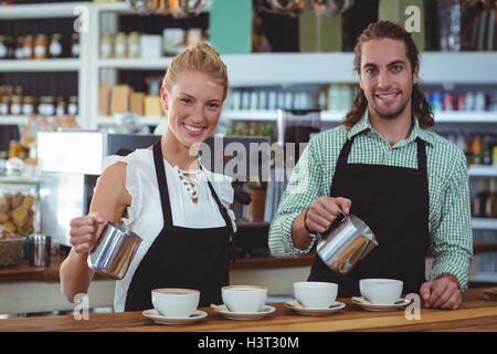 Portrait de serveur et serveuse qui tasse de café au comptoir Banque D'Images