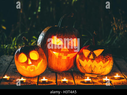 Citrouilles d'halloween tête jack lantern avec bougies autour de l'ancien dans un paysage de nuit fantasmagorique. soft focus dof peu profondes. Banque D'Images