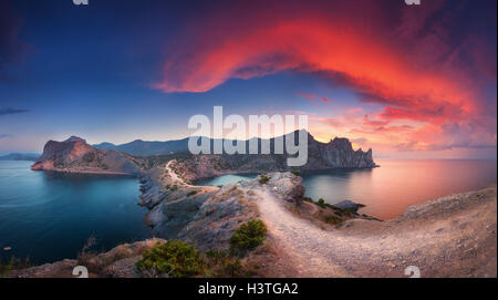 Beau paysage d'été avec montagnes, mer, ciel bleu et nuages rouges colorés magnifiques au coucher du soleil en Crimée Banque D'Images
