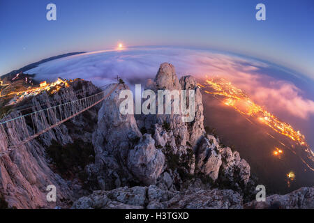 Paysage de montagne avec la hausse pleine lune et brouillard dans la ville la nuit. Beau paysage de nuit avec pic de montagne Banque D'Images