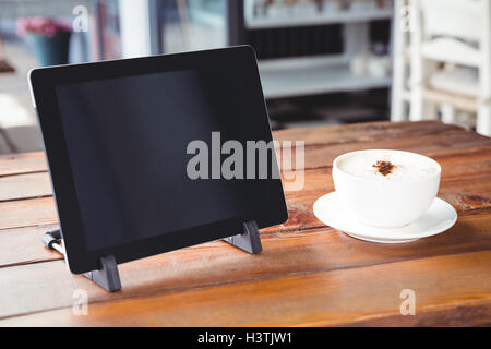 Tasse à café et tablette numérique sur une table Banque D'Images