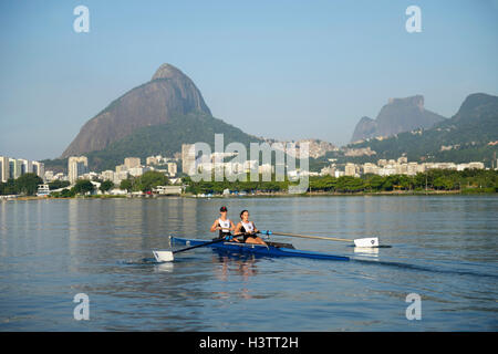 Deux jeunes femmes qui participent à la formation de l'aviron tôt le matin dans la Lagoa Rodrigo de Freitas Lagoon, à Rio de Janeiro Banque D'Images