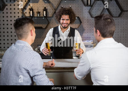 On y sert de la bière aux clients barman Banque D'Images