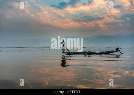 Ethnie Intha aviron pêcheur local avec une jambe, la pratique locale unique, le lever du soleil, l'aube, le lac Inle, l'État de Shan, Myanmar Banque D'Images