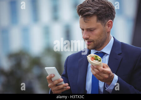Handsome businessman using mobile Banque D'Images