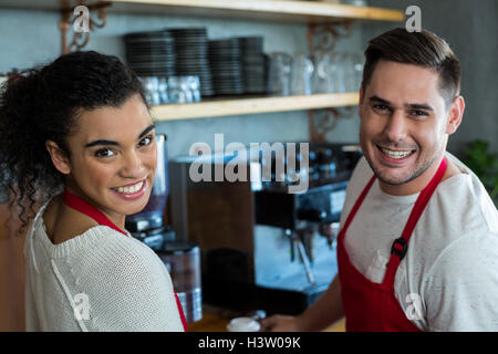 Smiling waitress and waiter in cafe Banque D'Images