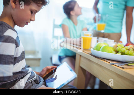 Boy using digital tablet avec petit-déjeuner sur la table Banque D'Images