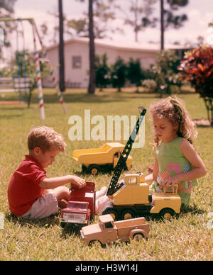 1970 Garçon Fille JOUER JOUET JARDIN JOUETS CAMIONS Grue de camion à benne Banque D'Images