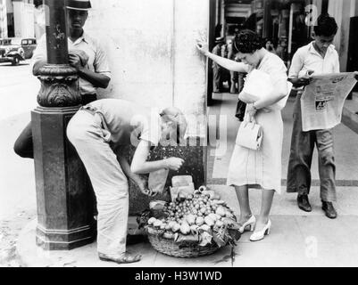 Années 1930 Années 1940 femme l'ACHAT DES FRUITS À PARTIR DE LA HAVANE CUBA DU VENDEUR DE TROTTOIR Banque D'Images