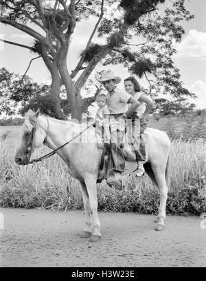 1950 HOMME FEMME ENFANT TOUS ASSIS SUR UN CHEVAL À LA CAMÉRA AU PRÈS DE LA VILLE DE DANS LA PROVINCE DE CAMAGUEY CUBA SIBANICU Banque D'Images