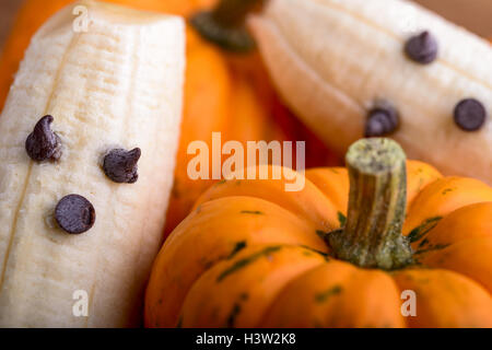 Les citrouilles et fantômes faits avec banane et chocolat pour l'halloween sur du bois Banque D'Images