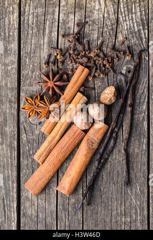 Vanille, cannelle, girofle, muscade et anis étoile sur vieille table en bois. Banque D'Images