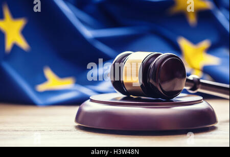 Les juges wooden gavel avec drapeau de l'UE dans l'arrière-plan. Symbole de la juridiction. Banque D'Images
