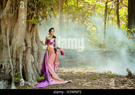 Femme debout dans la forêt portant des vêtements traditionnels, Thaïlande Banque D'Images