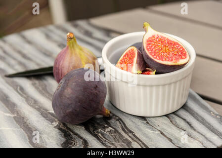 Image de figues fraîches sur table avec couteau et en planche à découper. Banque D'Images