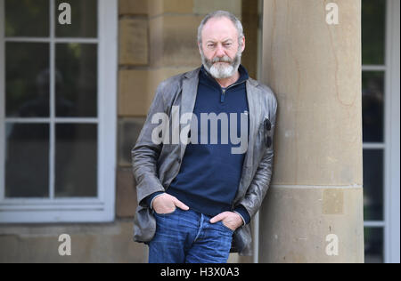 Stuttgart, Allemagne. 12 octobre 2016. Acteur Liam Cunningham, qui est connu comme "chevalier er Davos" de la série "Game of Thrones", se trouve entre les piliers à Stuttgart, Allemagne, 12 octobre 2016. À Stuttgart, il a rencontré le jeune garçon réfugié syrien Hussam Al-Heraki. L'acteur avait appris à connaître le garçon quand il a visité un camp de réfugiés en Jordanie avec l'organisation humanitaire World Vision. PHOTO : MARIJAN MURAT/dpa/Alamy Live News Banque D'Images