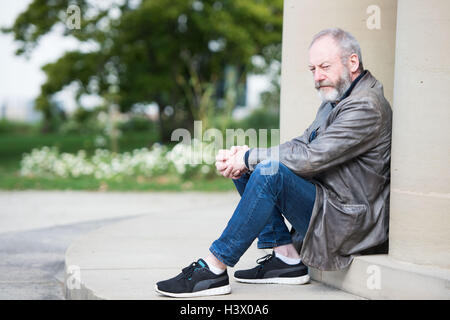 Stuttgart, Allemagne. 12 octobre 2016. Acteur Liam Cunningham, qui est connu comme "chevalier er Davos" de la série "Game of Thrones", se trouve entre les piliers à Stuttgart, Allemagne, 12 octobre 2016. À Stuttgart, il a rencontré le jeune garçon réfugié syrien Hussam Al-Heraki. L'acteur avait appris à connaître le garçon quand il a visité un camp de réfugiés en Jordanie avec l'organisation humanitaire World Vision. PHOTO : MARIJAN MURAT/dpa/Alamy Live News Banque D'Images