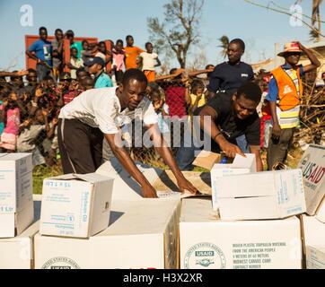 Les haïtiens se précipiter pour aider à décharger les fournitures par des Marines américains pour aider les personnes touchées par l'Ouragan Matthew 11 octobre 2016 à Dame Marie, en Haïti. L'ouragan Matthew a frappé Haïti, avec des vents de plus de 140-mph tuant 500 personnes et causant de lourds dommages. Banque D'Images