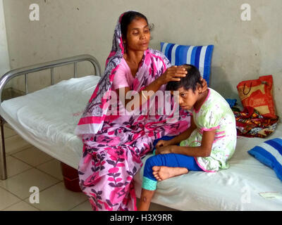 Dhaka 02 octobre 2016. Une femme montrant les cicatrices sur le corps de sa fille de 7 ans, à l'Jannat dirigé de de Dhaka Medical College Hospital récemment. Jannat, qui a travaillé en tant qu'enfant servante à Gazipur, près de la capitale du Bangladesh, était souvent battu son employeur, une femme au foyer. La dame a également utilisé pour brûler plusieurs parties du corps de la jeune fille avec un fer chaud et les ustensiles. Banque D'Images