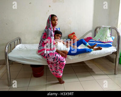 Dhaka 02 octobre 2016. Une femme montrant les cicatrices sur le corps de sa fille de 7 ans, à l'Jannat dirigé de de Dhaka Medical College Hospital récemment. Jannat, qui a travaillé en tant qu'enfant servante à Gazipur, près de la capitale du Bangladesh, était souvent battu son employeur, une femme au foyer. La dame a également utilisé pour brûler plusieurs parties du corps de la jeune fille avec un fer chaud et les ustensiles. Banque D'Images