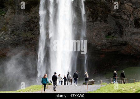 Les touristes en face de la cascade de Seljalandsfoss Islande Banque D'Images