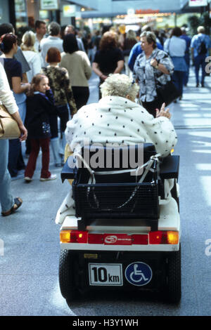 Ville, zone piétonne, passant, senior, electric invalide, fauteuil, vue de dos, à l'extérieur, de piétons, femme, invalide, fauteuil, fauteuil du conducteur non valide, obstacle, handicap physique, marche-marche entravée, obstacle, en besoin de soins Banque D'Images
