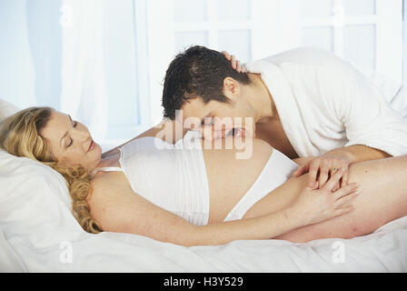 Lit, femme, enceinte, l'homme, de l'abdomen, morsure, parution du modèle, très proche, à la maison, en couple, les jeunes, les femmes enceintes, la gestation, la gestation, la gestation, fun, funny, heureux, tombe dans l'amour, l'affection, l'amour, touch, touch, affectueusement, la tendresse Banque D'Images