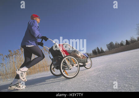 Jogger, landau, un hiver femme, l'écrou, 36 ans, baby joggers, jogging, course, du temps de loisirs, hobby, sport, l'activité, la condition physique, la joie de vie, les loisirs, la santé, de l'égaliseur, de la neige, au bord du lac lac série, Murnau, Haute-Bavière, Allemagne, 30-40 ans Banque D'Images