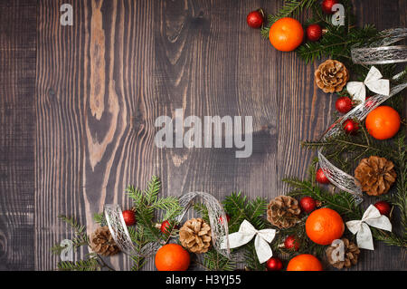 Boules de Noël rouge, branches de sapin et de tangerines on a wooden background Banque D'Images