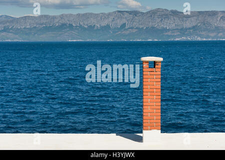 Une cheminée en brique rouge sur un bâtiment donnant sur la mer Adriatique à Trpanj Croatie Banque D'Images