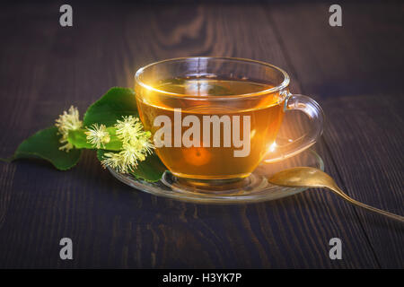 Linden plateau sur une table en bois dans une tasse en verre. Fleur de thé, de médecine de fines herbes. Banque D'Images