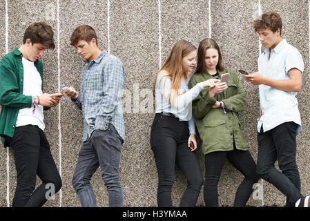 Groupe d'Adolescents Partager Message texte sur les téléphones mobiles Banque D'Images