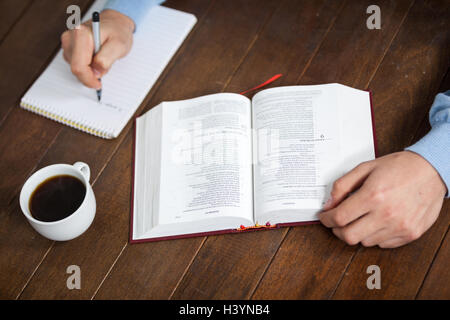 Homme avec une bible écrit sur le bloc-notes Banque D'Images