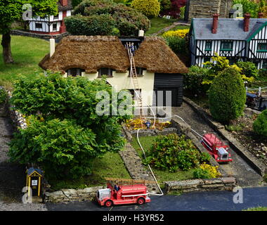 Véhicules d'incendie lors d'un incendie, représentés dans le village modèle de Bekonscot à Beaconsfield, dans le Buckinghamshire, en Angleterre, est le plus ancien village modèle original dans le monde. Elle décrit les aspects de l'Angleterre pour la plupart datant des années 1930. Banque D'Images