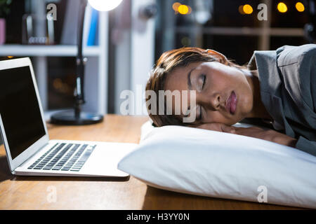Businesswoman working in office, tout en dormant Banque D'Images