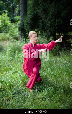 Woman practicing Tai Chi on grassy field Banque D'Images