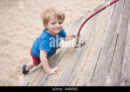 High angle view of smiling boy holding corde à jeux pour enfants Banque D'Images