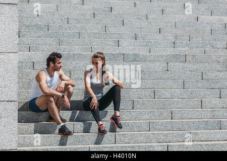 Amis parler alors qu'il était assis sur les marches après l'exercice Banque D'Images