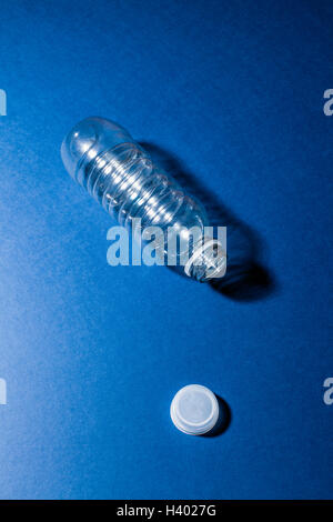 Portrait de bouteille en plastique vide sur la table bleu Banque D'Images