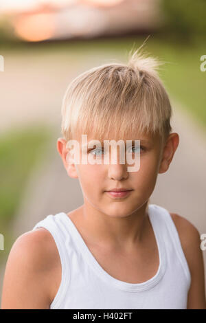 Portrait of boy with yeux gris debout à park Banque D'Images