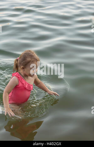 Cheerful girl maillot rose dans le lac permanent Banque D'Images