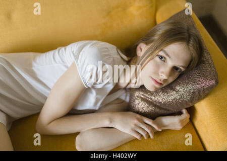 High angle portrait of young woman on sofa at home Banque D'Images