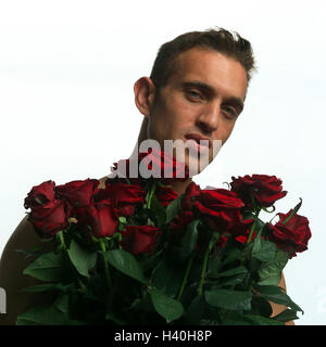 L'homme, jeune, bouquet de roses, portrait, modèle sorti, Chevalier de la rose, roses, rouges, donner, signe de l'amour, l'attention, 'laissez parler les fleurs", tombe amoureux, l'amour Banque D'Images