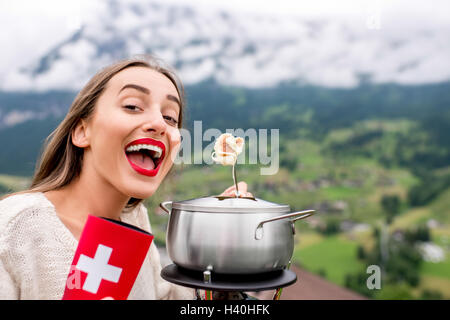 Femme avec fondue dans les montagnes Banque D'Images