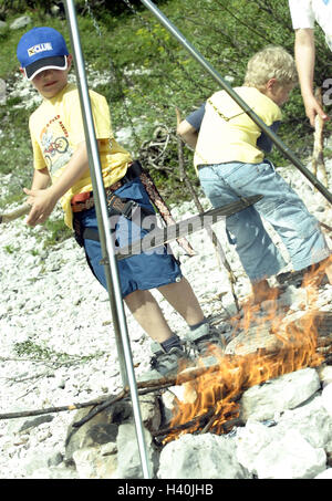 Riverbed, gravier, garçon, feu de camp, gril de rouille sur les enfants, sur 5 ans, amis, amitié, deux, de l'enfance, de l'extérieur, de plaisir, d'aventure, d'expérience, le feu, l'incendie, en bois, cheminée en bois, ajouter, de brûlures, d'avoir d'un barbecue, grill, danger, dangereusement, sans surveillance, somme Banque D'Images