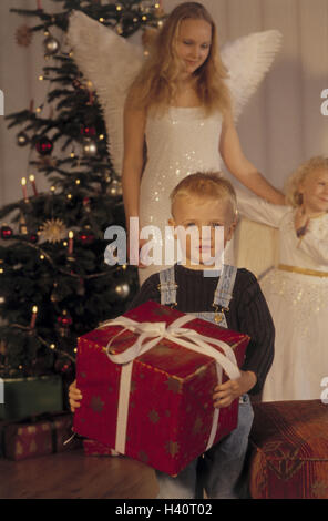 Noël, présente la distribution, girl, doublure, ange de Noël, garçon, présent, détient la veille de Noël, la veille de Noël, Noël, arbre de Noël, arbre de Noël, femme, enfants, anges, cadeau de Noël, d'emballer, de surprise, de fierté, de joie, de l'intérieur Banque D'Images